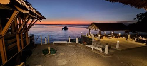 a dock with benches and a boat in the water at Aquaventure Reef Club in Mabini