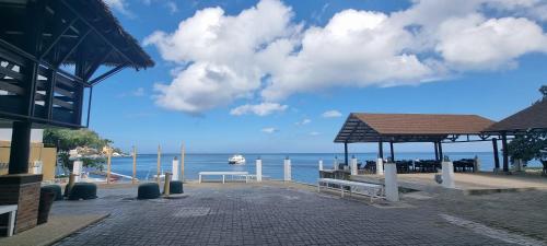 a view of a pier with a boat in the water at Aquaventure Reef Club in Mabini