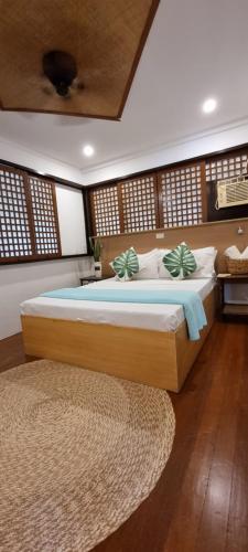 a bedroom with a large bed and a rug at Aquaventure Reef Club in Mabini