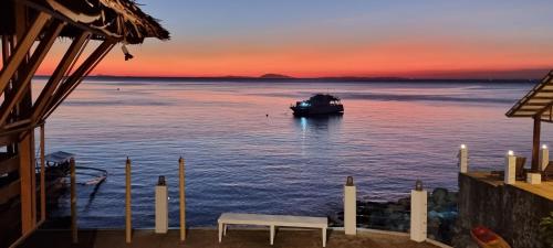 a boat in the water with a sunset at Aquaventure Reef Club in Mabini