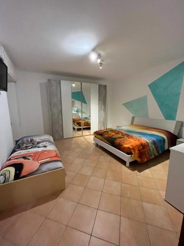 a bedroom with two beds and a tile floor at Un nido sul lago in Ranzanico