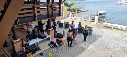a group of people standing near the water with luggage at Aquaventure Reef Club in Mabini