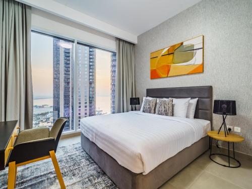 um quarto com uma cama grande e janelas grandes em Incredible Waterfront Apt with Panoramic Views em Dubai