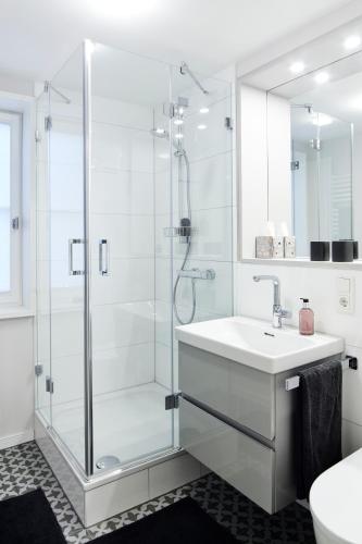 a white bathroom with a shower and a sink at Fachwerk-Romantik am Dom in Fulda