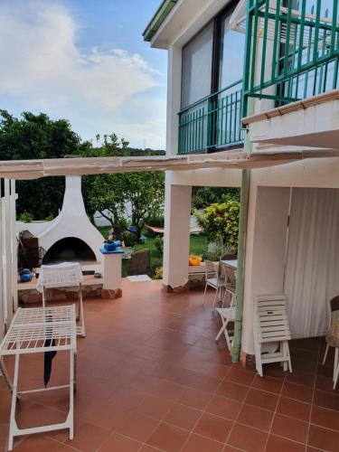un patio con sillas y una terraza con chimenea en Casa vacanze Nietta, en Cala Liberotto