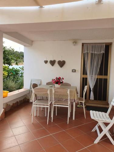 a dining room with a table and chairs and a window at Casa vacanze Nietta in Cala Liberotto