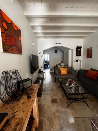 een woonkamer met een bank en een tafel bij La maison de Marie, maison de ville 4 personnes, option chambre patio 2 pers supp in Aigues-Mortes