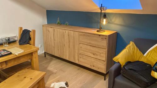 een woonkamer met een houten kast en een tafel bij Le Loire-Etain in Albiez-Montrond