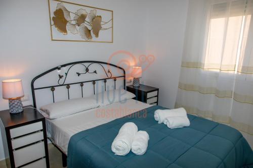 a bedroom with a bed with towels on it at APARTAMENTO ZEN. TEULADA. LIVE IT COSTABLANCA in Teulada
