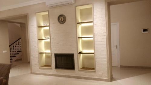 a white brick wall with a fireplace in a living room at Villa Gilavar in Baku