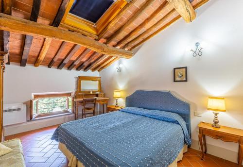 a bedroom with a blue bed in a room with wooden ceilings at Borgo Bucciano in San Miniato