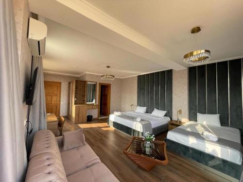 a hotel room with two beds and a couch at Tbili Metekhi Boutique Hotel in Tbilisi City