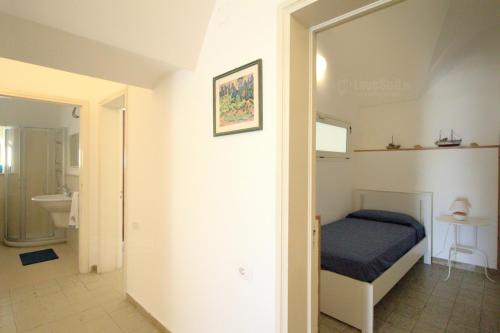 a small bedroom with a bed and a bathroom at Leuca lungomare by LoveSud in Leuca