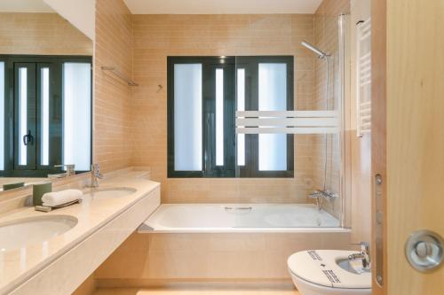 bagno con 2 lavandini, vasca e servizi igienici di Plaza Malta Oasis 2 Bajo a Fuente Alamo
