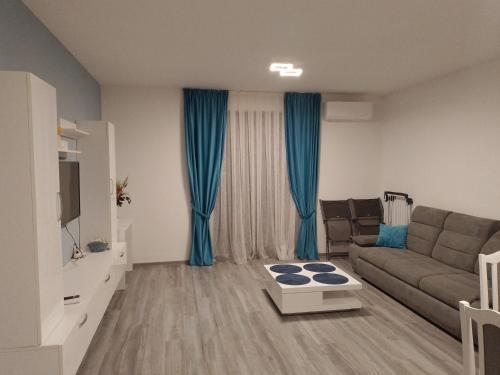 uma sala de estar com um sofá e cortinas azuis em Apartament 2 camere Lucian em Baile Felix