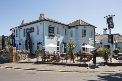 a blue building with tables and umbrellas in front of it at The Boat House - Isle of Wight in Seaview