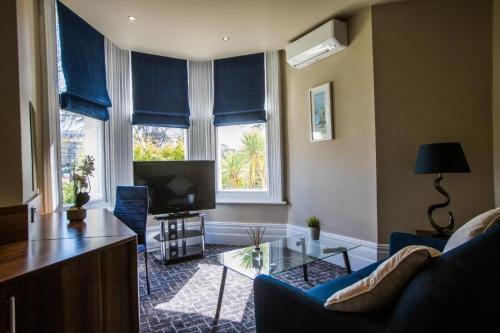 uma sala de estar com um sofá e uma televisão em No5 Durley Road - Contemporary serviced rooms and suites - no food available em Bournemouth