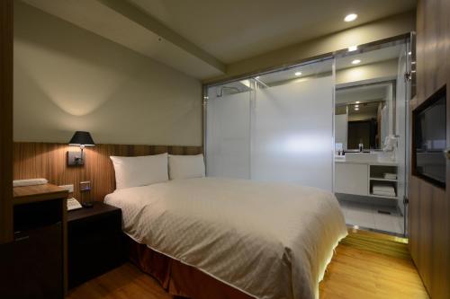 a bedroom with a large bed and a television at Smile Inn - Taipei Main Station in Taipei