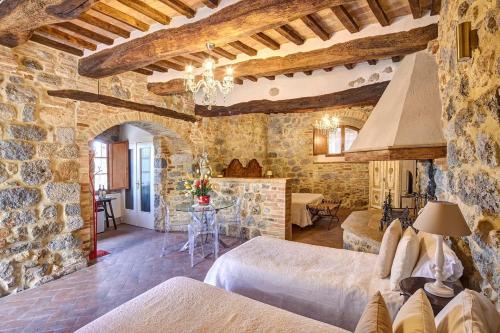 a bedroom with two beds and a stone wall at Antica Dimora in San Gimignano