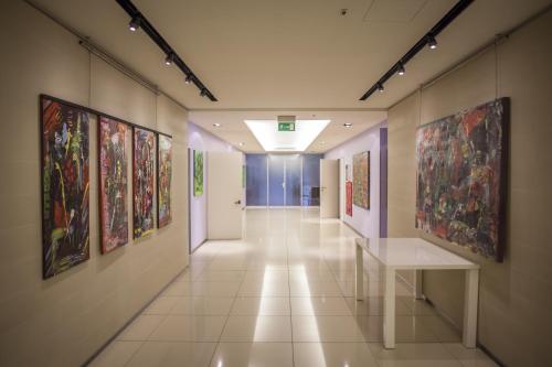 a hallway in a building with paintings on the walls at Just Hotel Lomazzo Fiera in Lomazzo