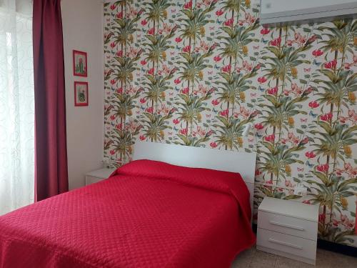 a bedroom with a bed with a red bedspread at Villa La Lanterna in Pietra Ligure