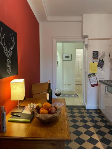 a table with a bowl of fruit and a bottle of wine at Stadtgärtchen in Lüneburg