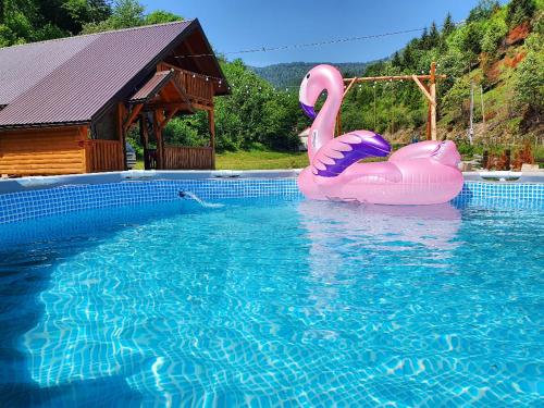 ein Pool mit zwei rosa Flamingos im Wasser in der Unterkunft Mysterylodge Bjelašnica Treskavica in Sarajevo