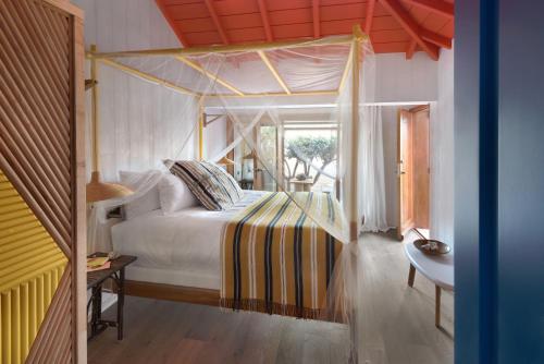 a bedroom with a bed with a canopy at Hotel Manapany in Gustavia