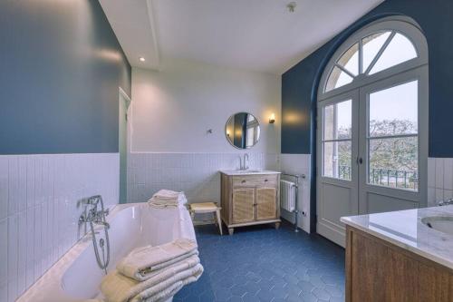 baño azul y blanco con bañera y lavamanos en NEW! 5 star classified Deluxe Wine Estate en Montagne