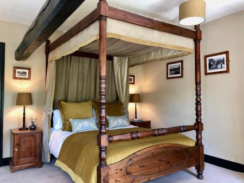 a bedroom with a wooden canopy bed in a room at Kirkstile Inn in Loweswater