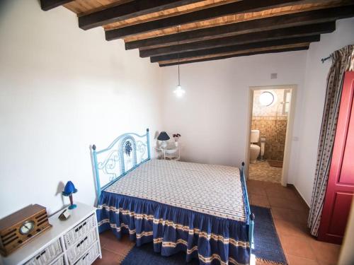 Schlafzimmer mit einem Bett mit blauer Tagesdecke in der Unterkunft Casa na Floresta in Figueira da Foz