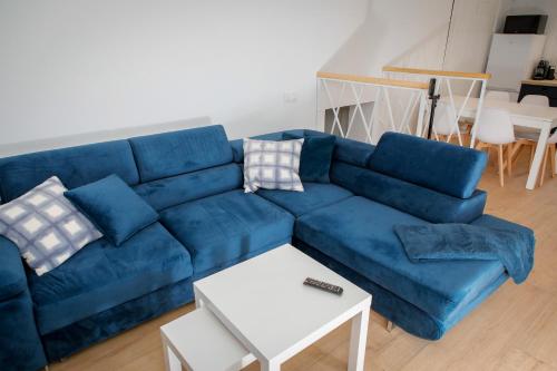 a blue couch in a living room with a table at Dom Granero w Lesie pod Ślężą in Strzegomiany