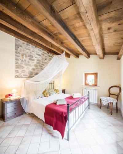 a bedroom with a large bed in a room with wooden ceilings at Agriturismo di là dall'Acqua in Fivizzano