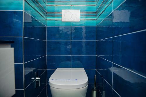 a blue tiled bathroom with a toilet in it at Villa Perledina by Wonderful Italy in Perledo