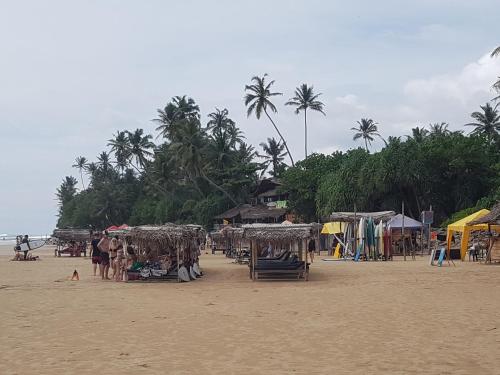 a beach with umbrellas and people on the sand at Kabalana Ocean Blue in Ahangama