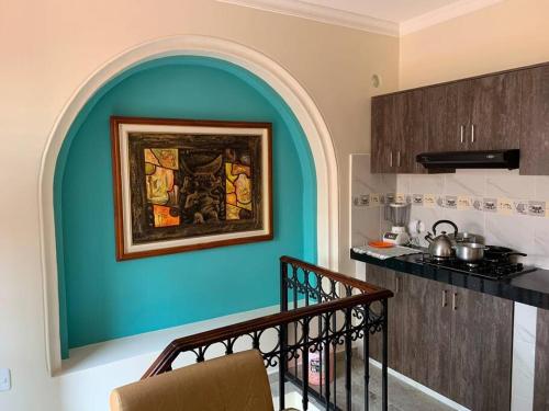 una cocina con una pared azul con una pintura en la pared en Hermosa suite plaza Foch, en Quito