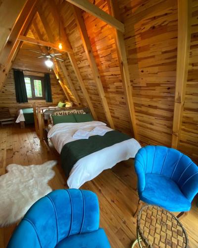 a bedroom in a log cabin with a bed and a chair at EMİS DAĞEVİ in Fındıklı