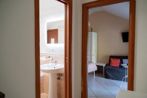 a bathroom with a sink and a room with a couch at Agriturismo Casa Scola in Gragnano