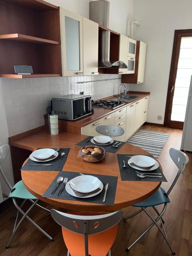 a kitchen with a wooden table with plates and chairs at Casa dei Tempesta in Noale