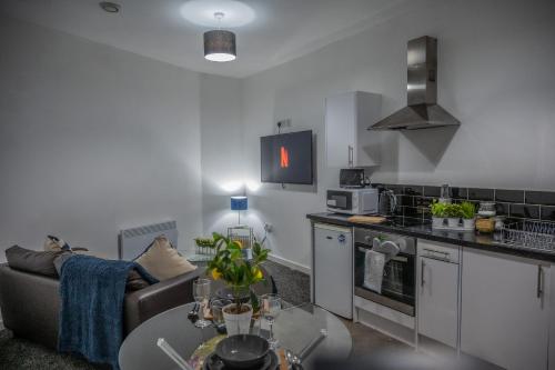 uma cozinha e sala de estar com um sofá e uma mesa em BV Homely 1 Bedroom Apartment At Shallow HIll Leeds em Huddersfield