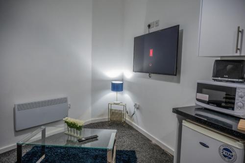 a living room with a tv and a coffee table at BV Homely 1 Bedroom Apartment At Shallow HIll Leeds in Huddersfield