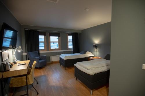 una camera d'albergo con 2 letti e una scrivania di Canyon Hotell ad Alta