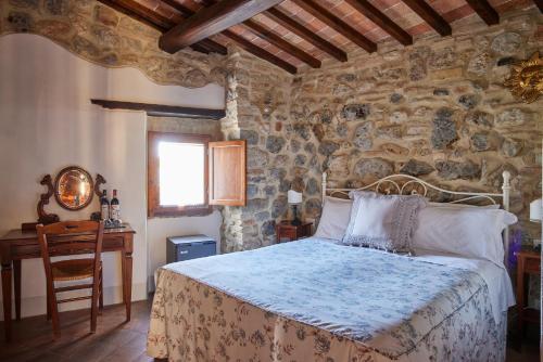 a bedroom with a bed and a table and a chair at Antica Dimora in San Gimignano