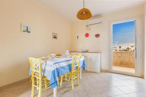 a dining room with a table and chairs and a window at Casa La Torre by BarbarHouse in Torre Mozza