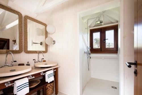 a bathroom with two sinks and a shower at Hotel Manapany in Gustavia