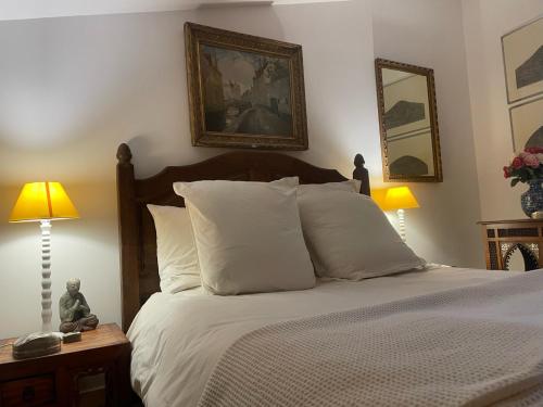 ein Schlafzimmer mit einem Bett mit weißer Bettwäsche und zwei Lampen in der Unterkunft Auberge Prieuré du Vieux Fox in Fox-Amphoux