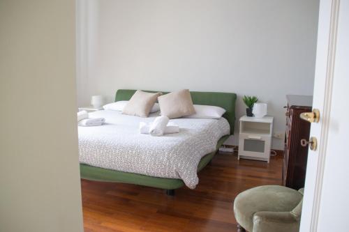 a bedroom with a green bed and a chair at Casa Rossana - WelcHome in Cannobio