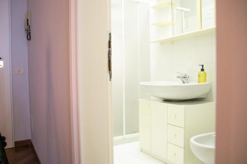 a white bathroom with a sink and a mirror at Casa Rossana - WelcHome in Cannobio