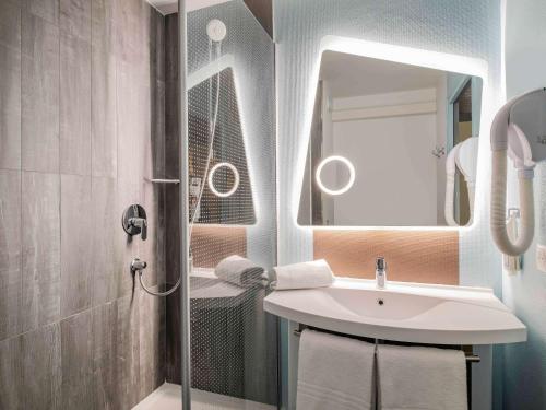 a bathroom with a sink and a shower with a mirror at ibis Amboise in Amboise