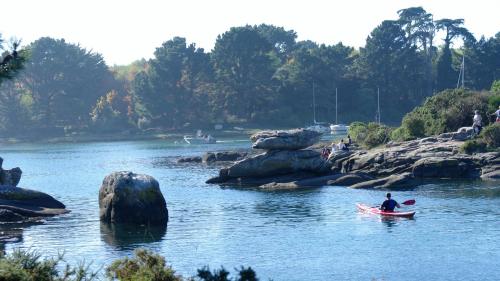 un hombre en un kayak en un río en A l'Ombre des Pommiers en Ergué-Gabéric